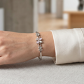 Silver bracelet on a wrist with a blurred indoor background